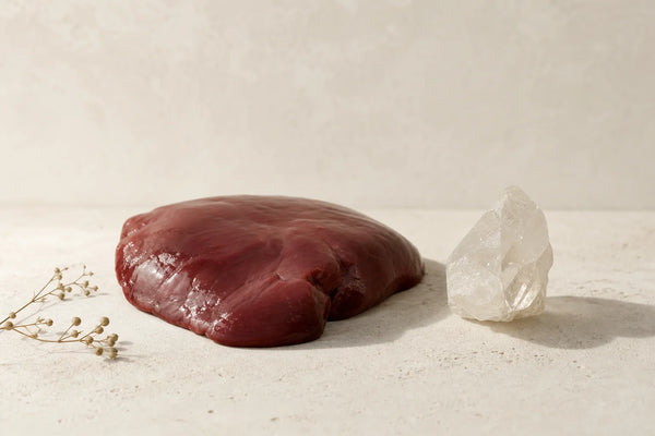 Raw beef liver tissue on a neutral background, representing the food-composition subject of the research review