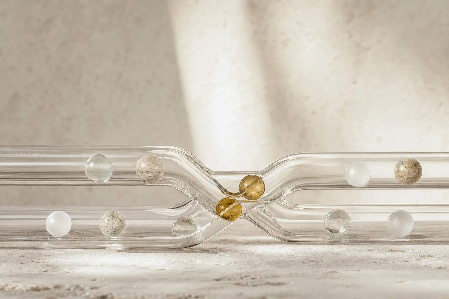 Mineral-like spheres moving through intersecting glass channels in a controlled interaction study
