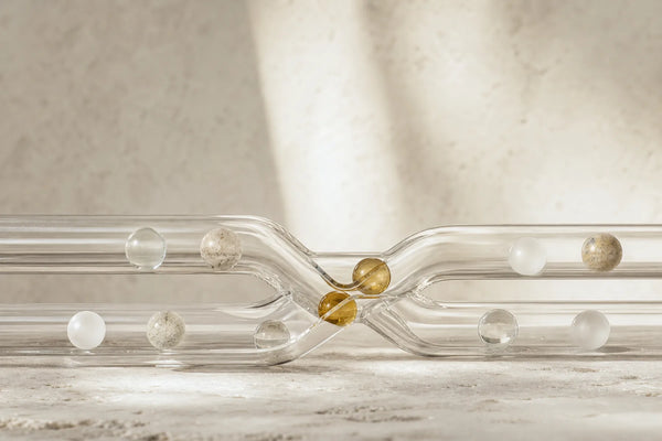Mineral-like spheres moving through intersecting glass channels in a controlled interaction study